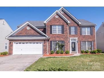 Charming two-story brick home with well-maintained lawn and attached two-car garage on a clear day at 10146 Hawkeye Dr # 2, Charlotte, NC 28273