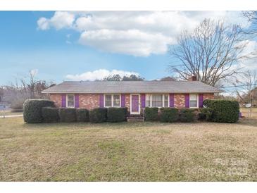 Charming single-story brick home featuring a well-maintained front yard, trimmed hedges, and colorful purple shutters at 1177 Craigbrow Cir, Chester, SC 29706