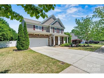 Charming two-story home featuring a stone and siding facade, attached garage, and well-manicured front lawn at 142 Wellshire St, Mooresville, NC 28115