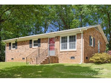 Charming brick ranch-style home with a well-maintained lawn and mature trees, offering curb appeal and a welcoming feel at 1975 Peace Rd, Fort Mill, SC 29715