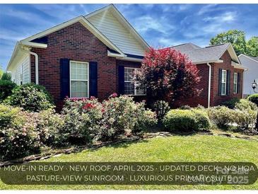 Charming brick home featuring mature landscaping and a well-manicured lawn on a sunny day at 2547 Bill Thompson Rd, Lancaster, SC 29720