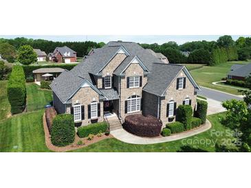 Beautiful two-story brick home featuring a well-manicured lawn and mature landscaping with a classic design and inviting curb appeal at 3000 J R Ct, Stanley, NC 28164