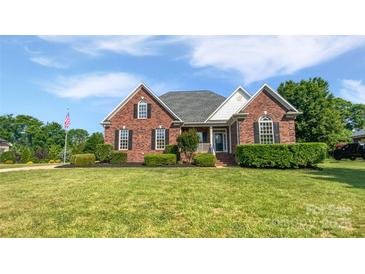 Charming brick home with manicured lawn, detailed landscaping, and traditional architectural details at 3124 Fairmead Dr, Concord, NC 28025