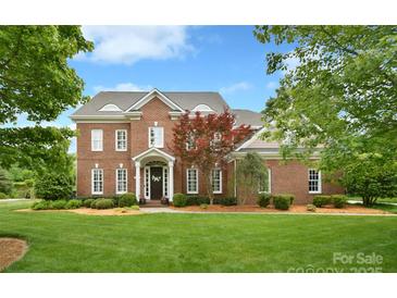 Stunning brick home boasts a lush lawn, complemented by mature landscaping and a classic architectural design at 5827 Rileys Ridge Rd, Charlotte, NC 28226