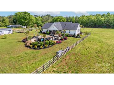 Expansive aerial view of a white home with a beautifully landscaped backyard and a fenced-in pasture at 754 Culp Ferguson Rd, Lancaster, SC 29720