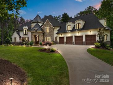 Stunning home with stone accents, a turret, three-car garage, and beautiful landscaping at 10170 Enclave Cir, Concord, NC 28027