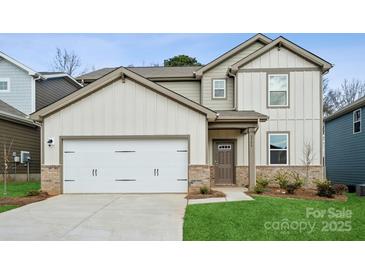 Two-story home featuring neutral siding, a two-car garage, brick accents, and a manicured lawn at 1113 Hallman Branch Ln, Lincolnton, NC 28092