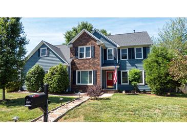 Charming two-story home with a brick and blue siding and a well-maintained lawn at 12601 Guardhouse Ct, Charlotte, NC 28262