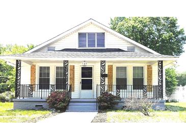 Charming home featuring a quaint porch, decorative railings, and lovely wooden shutters at 169 Freeze Nw Ave, Concord, NC 28025
