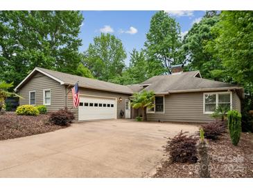 Ranch-style home with a two car garage, mature trees, and an American flag waving at 18 Shipmaster Ct, Clover, SC 29710