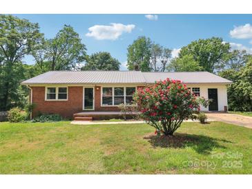 Charming single-story brick home with a well-maintained lawn and mature trees at 205 Dogwood Ln, Dallas, NC 28034