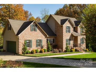 Charming brick two-story home with lush landscaping and a well-manicured lawn at 2101 Congress Ct, Kannapolis, NC 28083