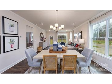 Open-concept dining area showcases a modern chandelier and transitions into a naturally lit living space at 4214 Steel Way, Sherrills Ford, NC 28673