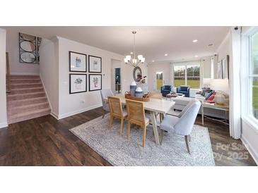 Bright dining area with hardwood floors, decorative rug, stylish decor, and access to living room at 4216 Steel Way, Sherrills Ford, NC 28673