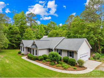 Charming ranch-style home with lush landscaping, attached garage, and well-manicured lawn at 5903 Wm Griffin Rd, Monroe, NC 28112