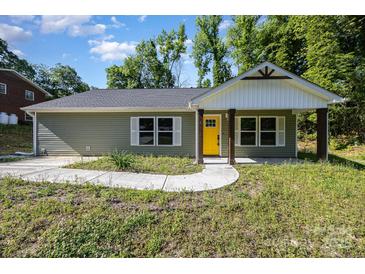 Charming single-story home with a bright yellow front door and neatly landscaped yard at 611 Fernwood Dr, Albemarle, NC 28001