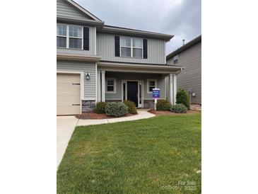 Charming two-story home with a two car garage, beautifully landscaped yard, and gray siding at 704 Robert Moses Dr # 121, Gastonia, NC 28056