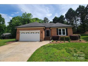 Charming brick home with a well-manicured lawn, attached garage, and welcoming front entrance at 1132 Preakness Nw Ct # 24, Concord, NC 28027