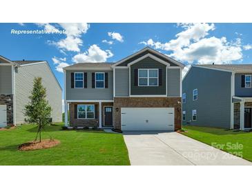 Charming two-story home featuring a two-car garage, landscaped lawn and neutral tones at 129 Way Cross Ln, Troutman, NC 28166