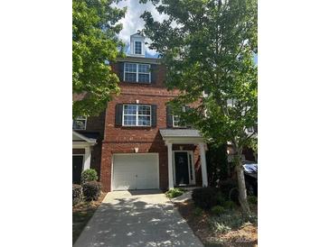 Charming brick townhome with a one-car garage and well-maintained landscaping at 1295 Amber Ridge Nw Rd, Concord, NC 28027