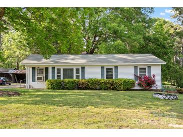 Charming single-story home with white siding, green shutters, and beautifully landscaped front yard at 130 Casper Rd, Gold Hill, NC 28071