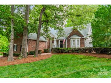 Charming brick and siding home with well-manicured lawn and lush greenery at 134 Lawrence Tee Ln, Mooresville, NC 28117