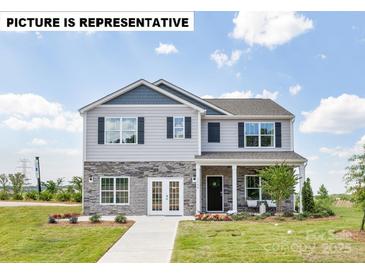 Charming two-story home with stone accents and a welcoming front porch perfect for enjoying the outdoors at 135 Calvin Creek Dr, Troutman, NC 28166