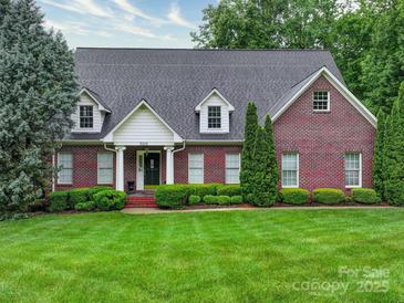 Charming red brick home with manicured lawn, mature trees and dormer windows provides excellent curb appeal at 3015 Hamptonbrook Dr, Gastonia, NC 28056