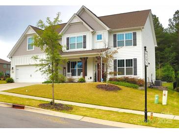 Charming two-story home features a welcoming front porch, manicured lawn, and inviting curb appeal at 6016 Willow Pin Ln, Huntersville, NC 28078
