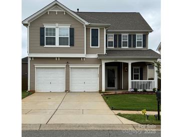 Charming two-story home featuring a two-car garage, covered porch, and well-maintained lawn at 6509 Ridgeview Commons Dr, Charlotte, NC 28269