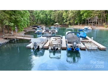 An array of covered boats docked on a serene lake with lush green trees in the background at 7687 Bermuda Hills Ln, Denver, NC 28037
