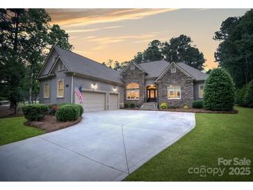 Beautiful home with stone accents, a spacious driveway, and a well-maintained lawn creating curb appeal at 7687 Bermuda Hills Ln, Denver, NC 28037