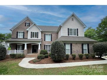 Beautiful brick two-story home with black shutters and landscaped front yard at 9624 Barnburgh Ln, Huntersville, NC 28078