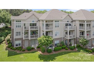 Beautiful condo building with multiple balconies, lush landscaping, and brick accents at 108 Pier 33 Dr # 414, Mooresville, NC 28117
