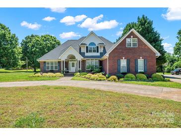 Charming brick two-story home with manicured landscaping and a curved driveway at 14340 Kendalton Meadow Dr, Mint Hill, NC 28227