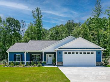 Charming single-story home featuring blue siding, a two-car garage, and a well-maintained front yard at 1994 Hollybrook Ln # 17, Lancaster, SC 29720