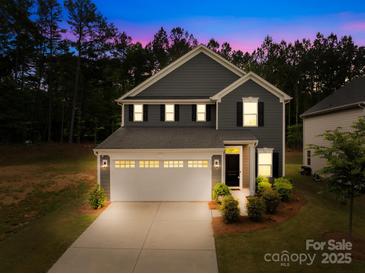 Charming two-story home with a manicured lawn, attached two-car garage, and welcoming curb appeal at 2012 Slippery Rock Ln, Monroe, NC 28112