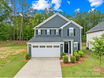 Charming two-story home featuring a two-car garage, landscaped yard, and classic architectural details at 2012 Slippery Rock Ln, Monroe, NC 28112