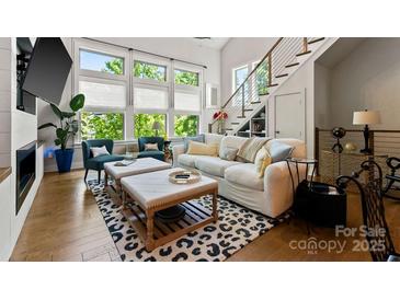 Bright living room with large windows, hardwood floors, and a modern fireplace, creating a welcoming atmosphere at 2518 Marshall Pl, Charlotte, NC 28203