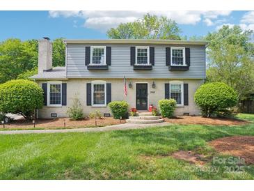Charming two-story home featuring a brick facade, gray siding, and well-manicured landscaping at 3918 Rea Rd, Charlotte, NC 28226