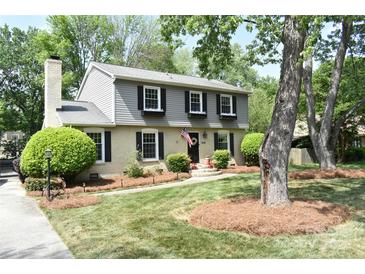 Charming two-story home with gray and brick exterior, manicured lawn, and mature trees at 3918 Rea Rd, Charlotte, NC 28226