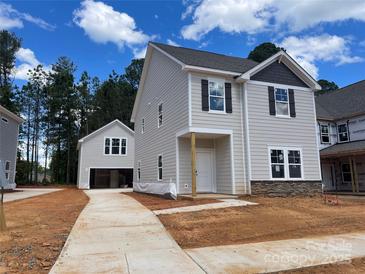 Charming two-story home with a detached garage and modern siding on a spacious lot at 4025 Grommet Ct # 5, Matthews, NC 28105