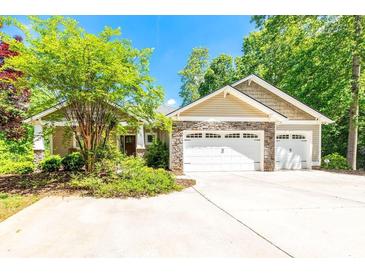 Charming single-story home with stone accents, manicured landscaping, and an attached two-car garage at 46827 Tall Whit Rd, New London, NC 28127