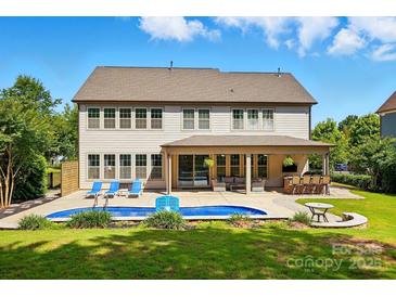 Lovely backyard featuring a private pool, outdoor seating, and covered patio area at 5105 Paisano Ln, Waxhaw, NC 28173