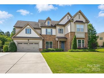 Charming two-story home with stone accents, three-car garage and well-manicured lawn at 5105 Paisano Ln, Waxhaw, NC 28173
