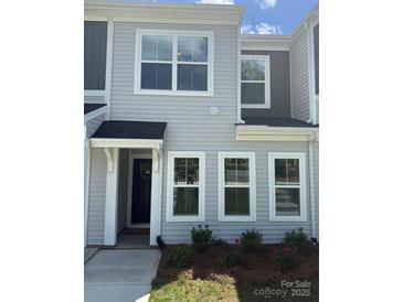 Charming two-story home with classic siding, multiple windows, and a cozy front porch at 5817 Tuckaseegee Rd, Charlotte, NC 28208