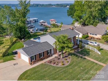 Charming brick home boasts lakeside living with docks, pool and lush green lawns at 8005 Island View Ct, Denver, NC 28037
