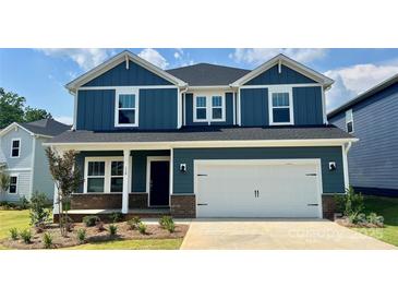 Beautiful, two-story home with a blue exterior, white trim, and a spacious two-car garage in a residential neighborhood at 110 Obadiah Ct, Mooresville, NC 28115