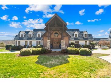 Stately home with brick and timber entrance, manicured lawn, and dormer windows at 12613 Oak Grove Rd, Stanfield, NC 28163