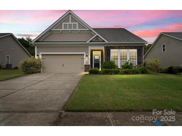 Charming single-Gathering home with a two-car garage, complemented by a lush lawn and manicured landscaping at 1409 Tupelo Rd, Clover, SC 29710